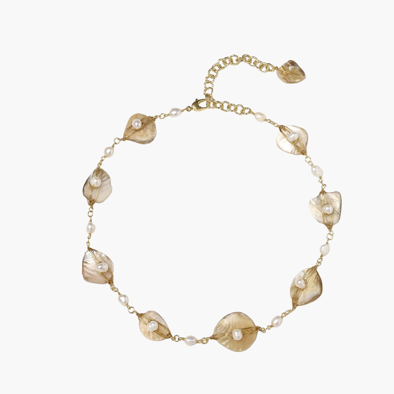 Gold-plated necklace with wire-wrapped shell pieces and freshwater pearls on neutral background, adjustable chain visible.
