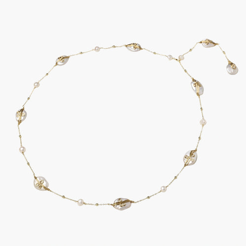 Long gold chain necklace with baroque pearls wrapped in leaf designs and small freshwater pearls spaced along the strand