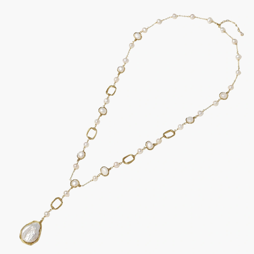 Long gold-plated necklace with alternating freshwater pearls and crystal bezels, featuring a large baroque pearl pendant