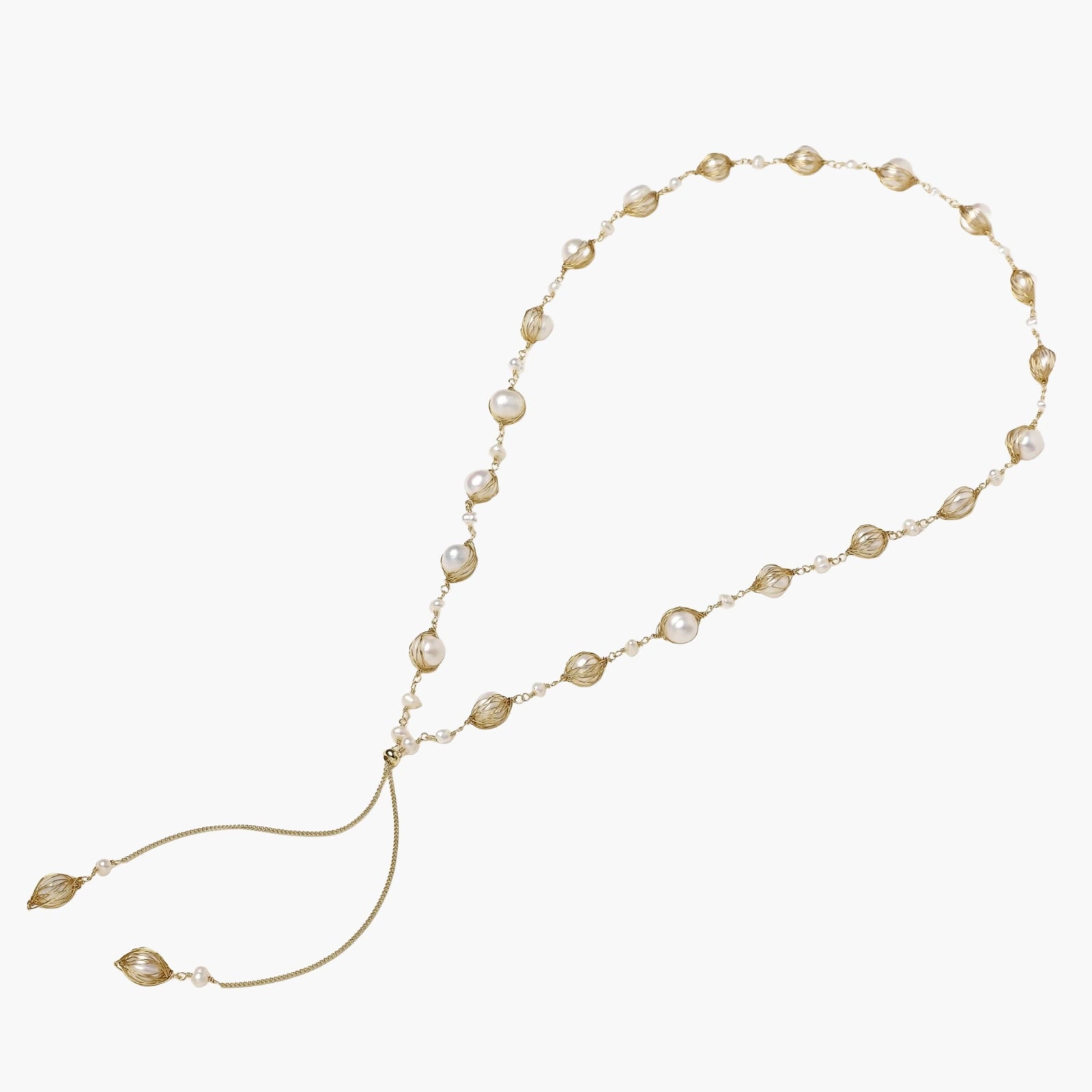 Adjustable gold lariat necklace with freshwater pearls nested in delicate cage settings and Y-shaped tassel drop