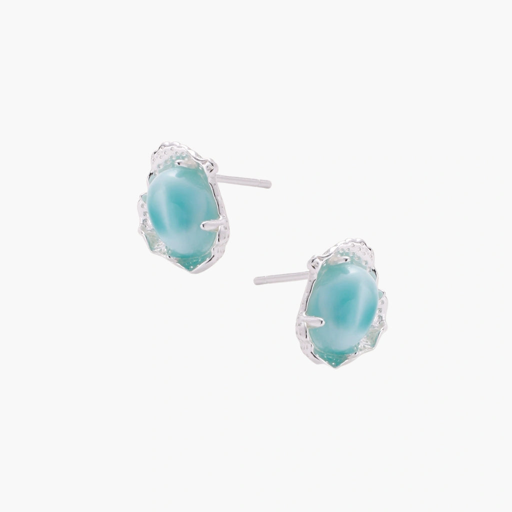 Oval larimar gemstone studs with ornate silver settings showing natural turquoise marbling on cream background