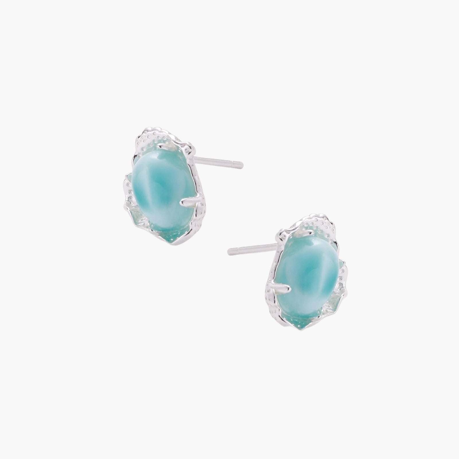 Oval larimar gemstone studs with ornate silver settings showing natural turquoise marbling on cream background