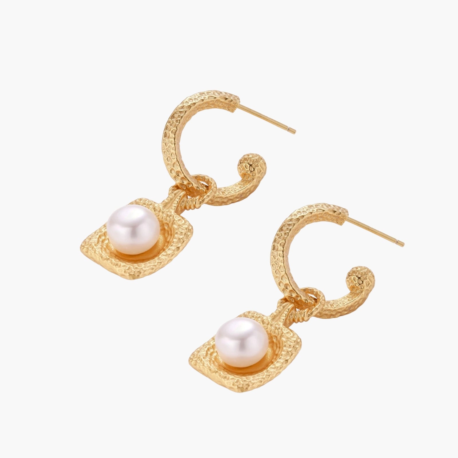 Pair of gold vermeil hoop earrings with textured square frames holding freshwater pearls on cream background