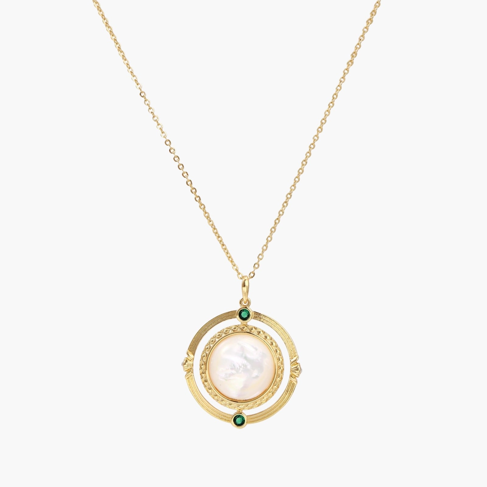 Gold pendant necklace with circular orbital design, iridescent mother-of-pearl center, and green zirconia accents