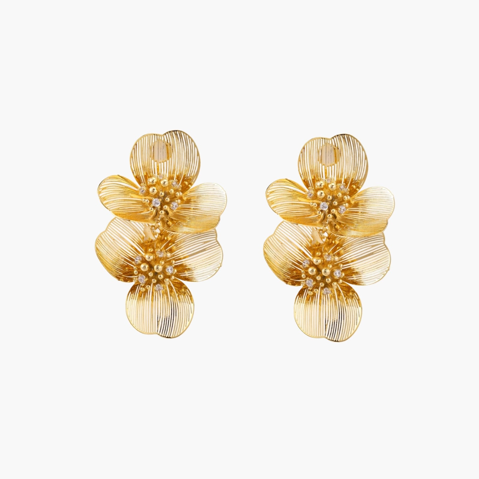 Pair of gold-plated double flower earrings with textured petals and crystal centers on cream background.