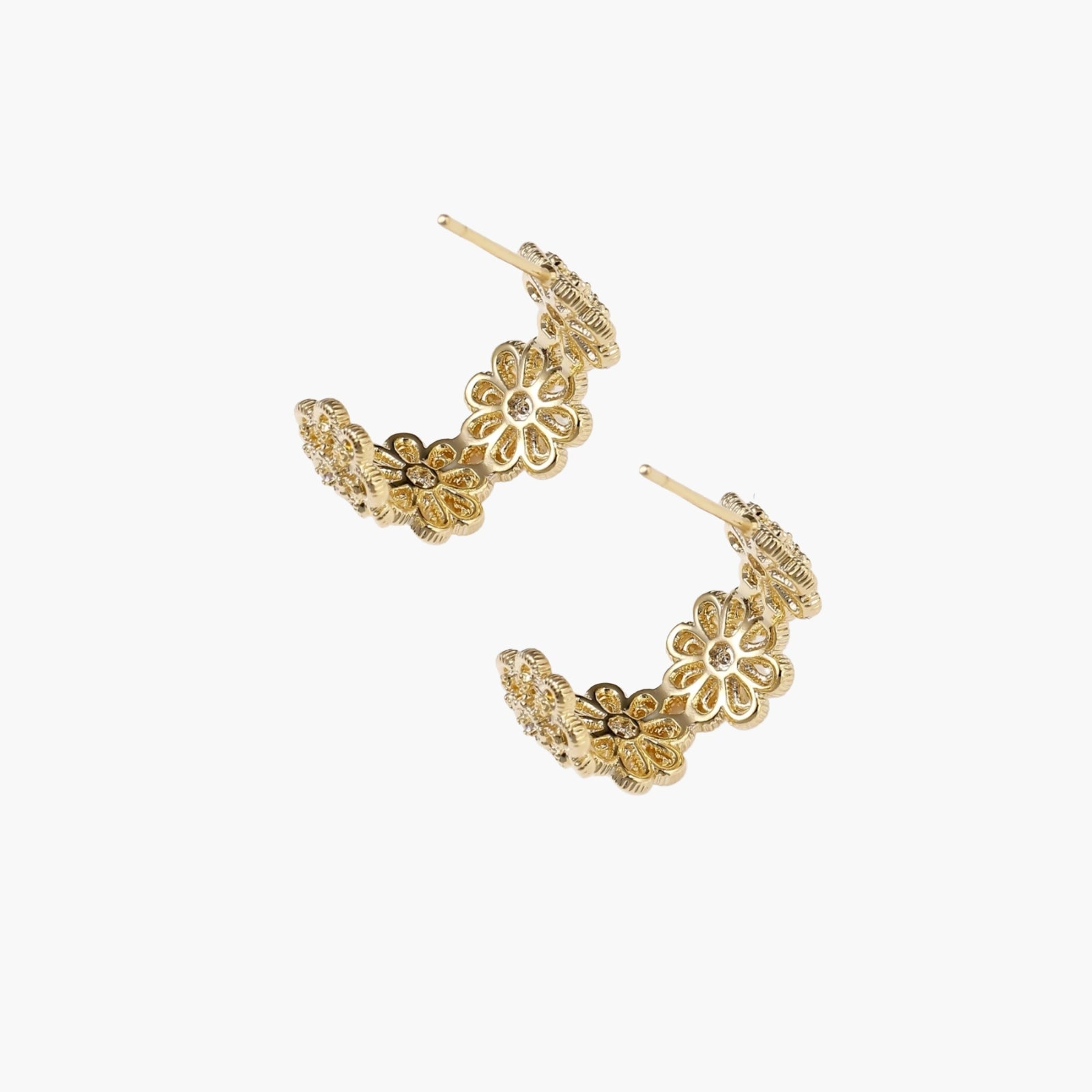 Gold hoop earrings with intricate three-dimensional floral filigree pattern in 14K gold plated brass on cream background