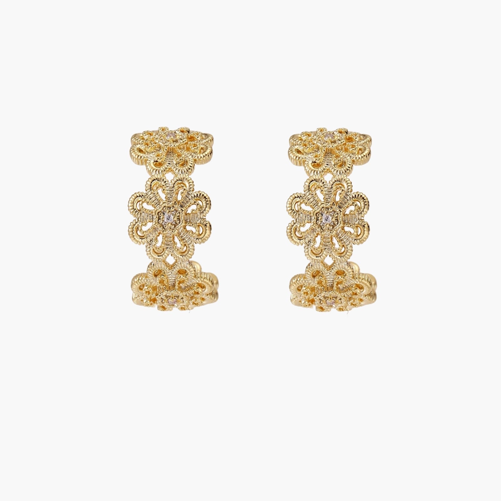 Gold hoop earrings with intricate three-dimensional floral filigree pattern in 14K gold plated brass on cream background